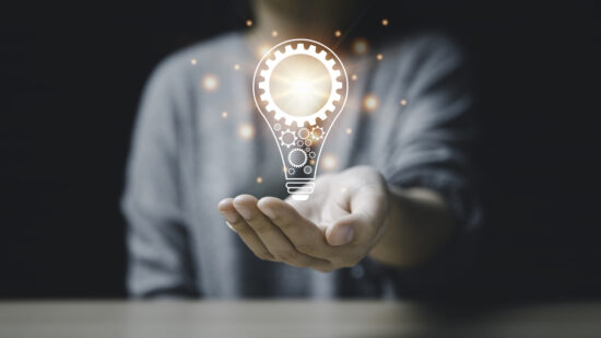 On the hand of a women with icon a light bulb And there is a gear icon on it. bright light bulb is idea innovation creativity inspiration brainstorming and imagination. technology education intellectual symbol future invention strategy energy light brain.